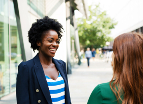 A woman speaks to another woman.