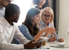 A woman having a discussion with four other associates.