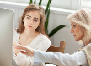 Two women looking at a computer monitor.