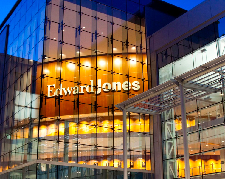 Exterior shot of an Edward Jones glass building at night.