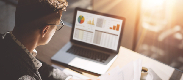 Male working from home at a desk on laptop.